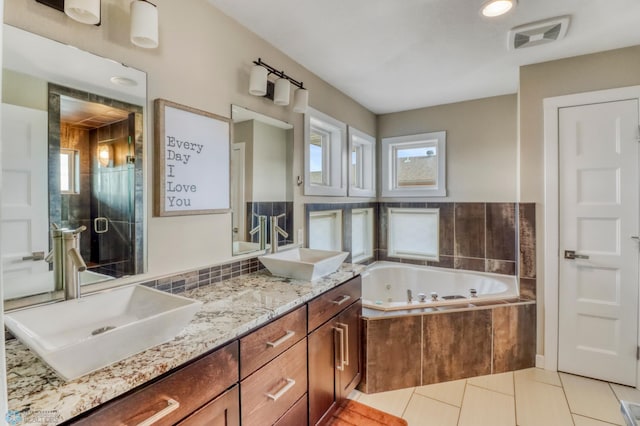 bathroom with a sink, a whirlpool tub, visible vents, and tile patterned floors