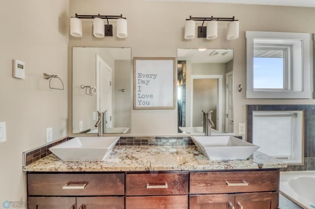 full bathroom featuring double vanity, a sink, and a washtub