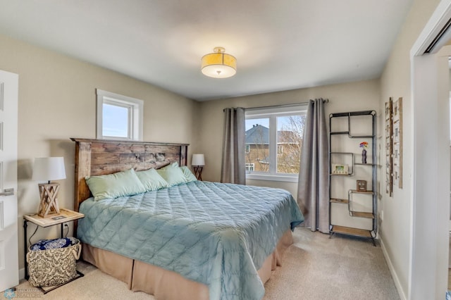 bedroom with light carpet, baseboards, and multiple windows