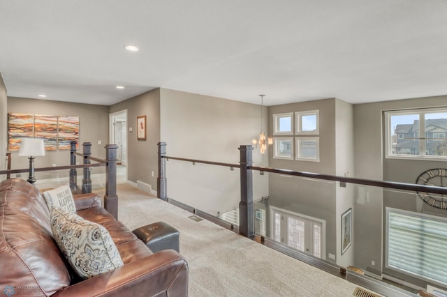 sitting room with carpet, a notable chandelier, an upstairs landing, and recessed lighting