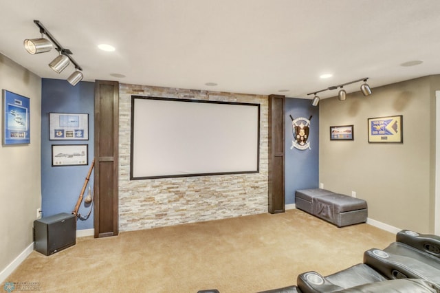 carpeted cinema room with rail lighting and baseboards