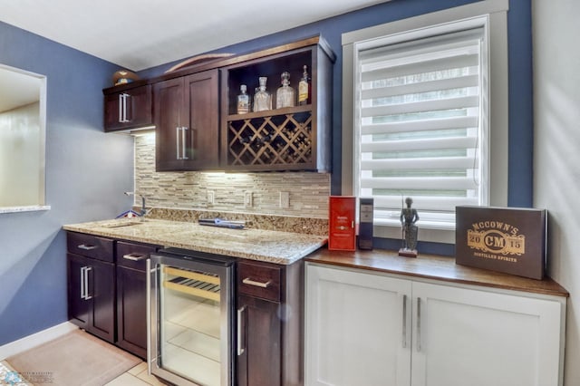 bar with backsplash, a healthy amount of sunlight, a dry bar, and beverage cooler