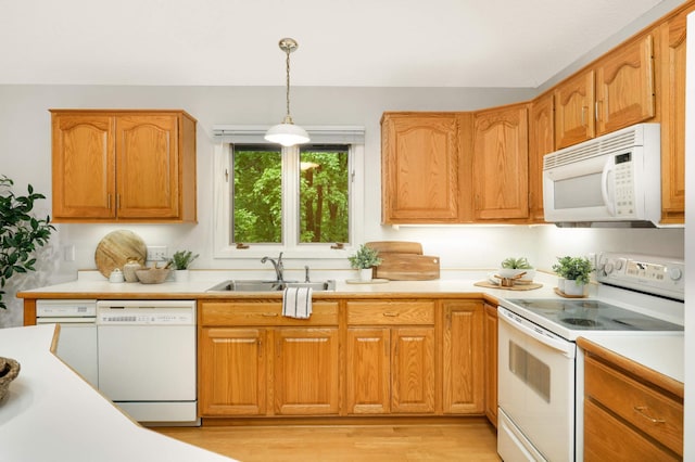 2117 Indian Rd W, Minnetonka, MN 55305 - kitchen featuring white appliances, a sink, light countertops, and hanging light fixtures