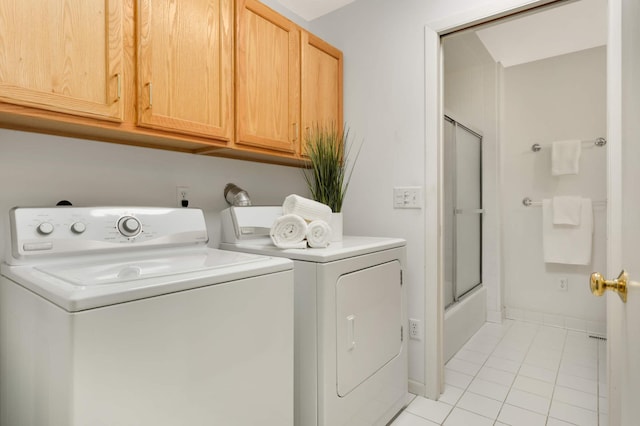 2117 Indian Rd W, Minnetonka, MN 55305 - laundry area featuring washing machine and clothes dryer, light tile patterned floors, and cabinet space