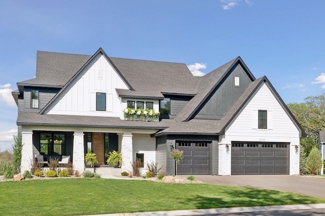 modern inspired farmhouse featuring board and batten siding, covered porch, an attached garage, driveway, and a front lawn