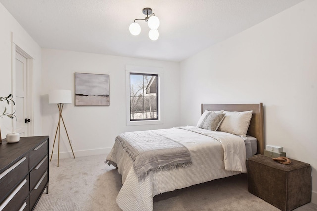 bedroom with light colored carpet and baseboards