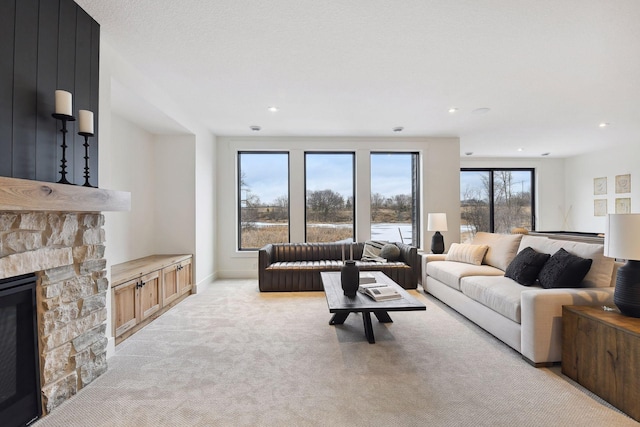 living room featuring light colored carpet, baseboards, a fireplace, and recessed lighting