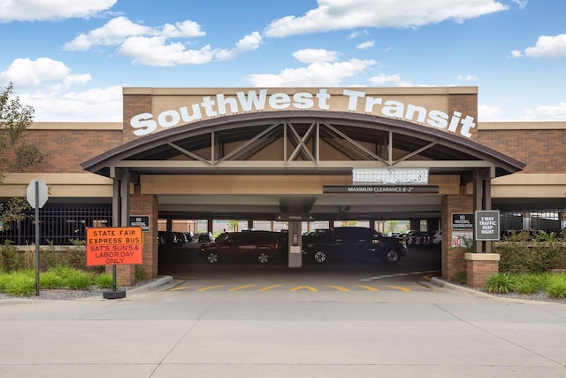 view of commercial property with covered parking and fence