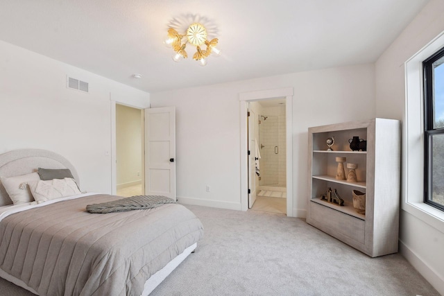 bedroom featuring light colored carpet, baseboards, and ensuite bath
