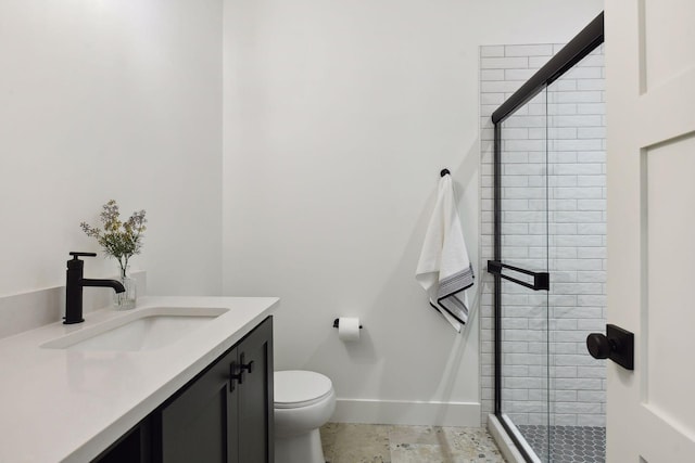 full bathroom featuring a stall shower, toilet, vanity, and baseboards
