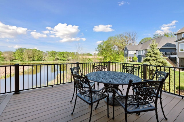 wooden terrace featuring outdoor dining space and a water view