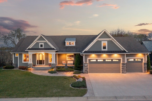 craftsman inspired home featuring a yard, covered porch, an attached garage, and concrete driveway