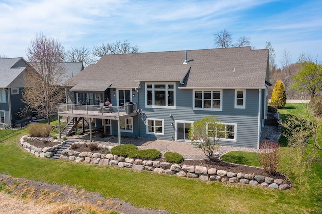 rear view of property with a deck, a yard, a patio area, and stairway