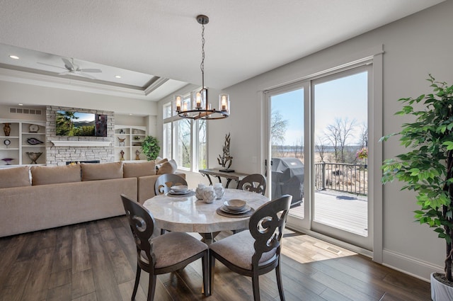 dining room with plenty of natural light, dark wood finished floors, baseboards, and an inviting chandelier