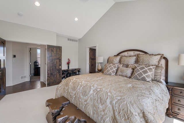 carpeted bedroom with high vaulted ceiling, recessed lighting, wood finished floors, and visible vents