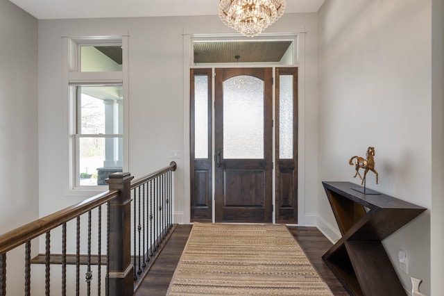 entrance foyer with baseboards, a notable chandelier, and dark wood-style floors