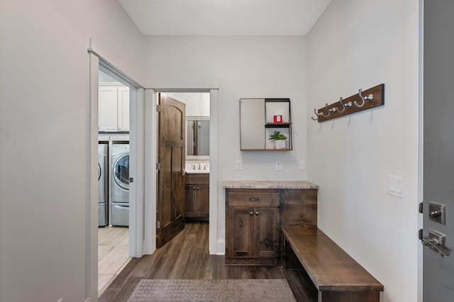 laundry room featuring washer / dryer, dark wood-style flooring, and cabinet space
