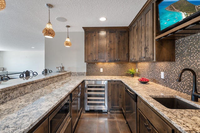kitchen featuring appliances with stainless steel finishes, a sink, a textured ceiling, wine cooler, and backsplash