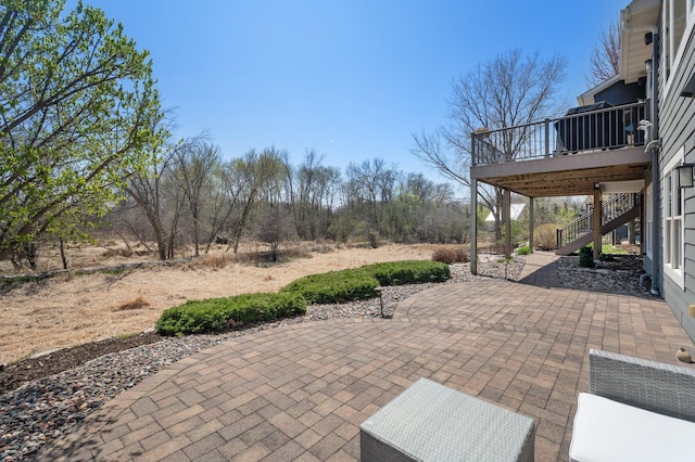 view of patio / terrace with a wooden deck and stairway