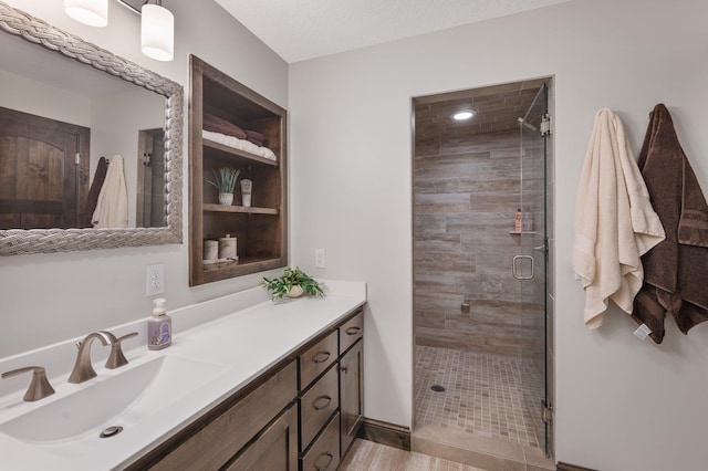 bathroom featuring vanity, a stall shower, and wood finished floors