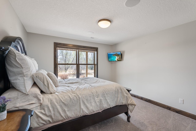 carpeted bedroom with a textured ceiling and baseboards