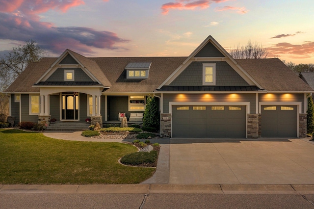 craftsman-style home featuring a shingled roof, stone siding, a garage, a front yard, and concrete driveway
