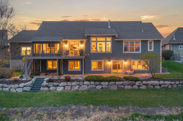 back of property with stairway, a lawn, and a deck