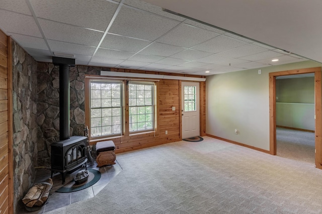 2064 View Dr NW, Walker, MN 56484 - unfurnished living room with a wood stove, a drop ceiling, carpet, baseboards, and wooden walls