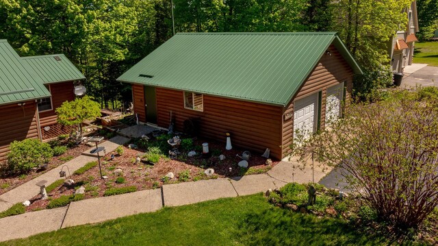 2064 View Dr NW, Walker, MN 56484 - view of side of home featuring faux log siding, a garage, and metal roof