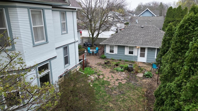 view of home's exterior with roof with shingles and a patio area