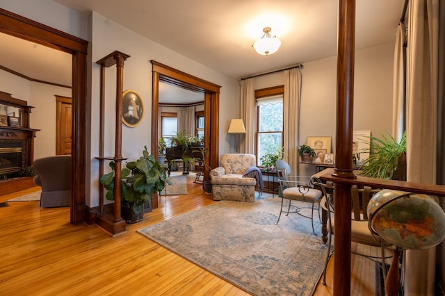 sitting room featuring light wood finished floors and ornate columns