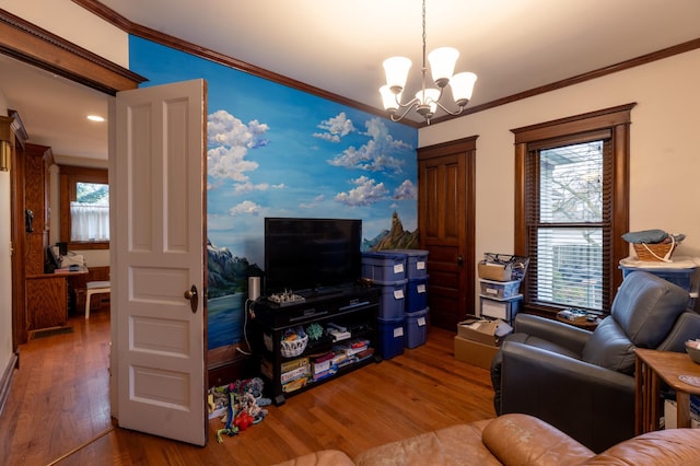 living area featuring crown molding, wood finished floors, and a chandelier