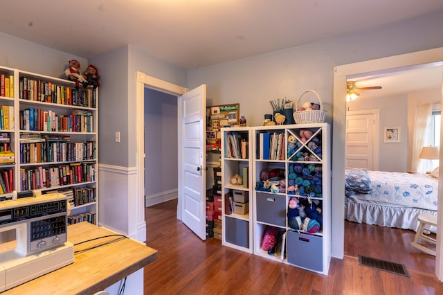 interior space with a ceiling fan, visible vents, and wood finished floors