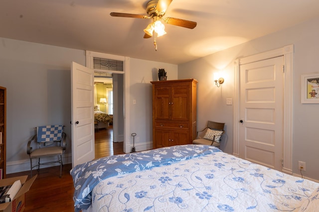 bedroom with baseboards, ceiling fan, and dark wood-type flooring
