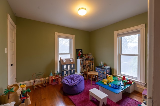 playroom featuring baseboards and wood finished floors