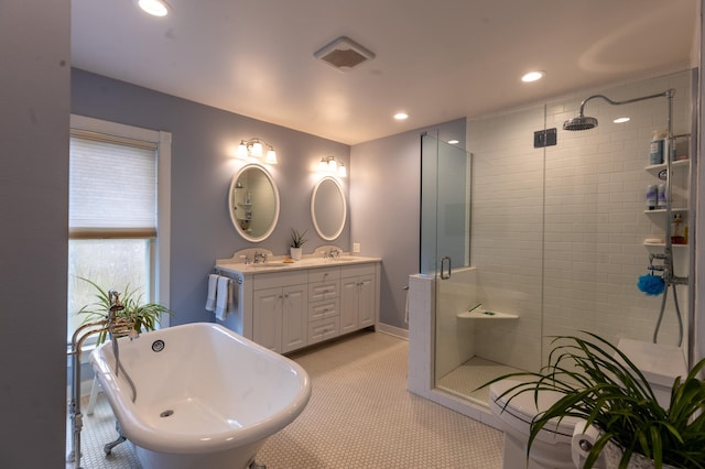 bathroom with double vanity, recessed lighting, a soaking tub, a sink, and a shower stall