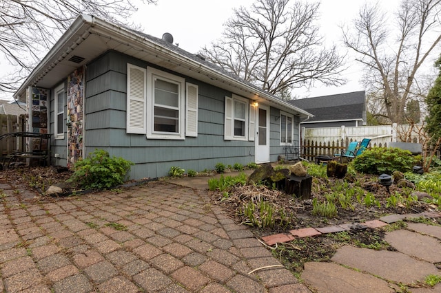 view of property exterior featuring a patio area and fence