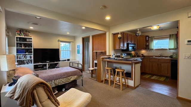 kitchen with dark countertops, plenty of natural light, a sink, and black appliances