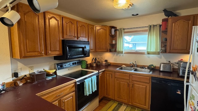 kitchen with dark countertops, open shelves, brown cabinets, a sink, and black appliances