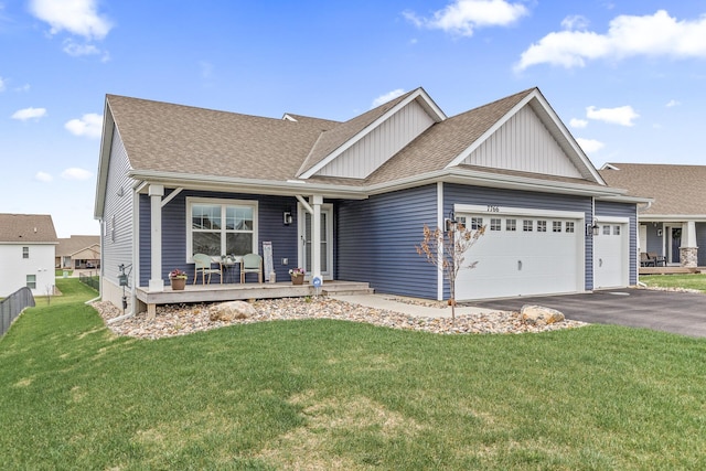 view of front of home featuring a porch, driveway, a front yard, a garage, and a shingled roof