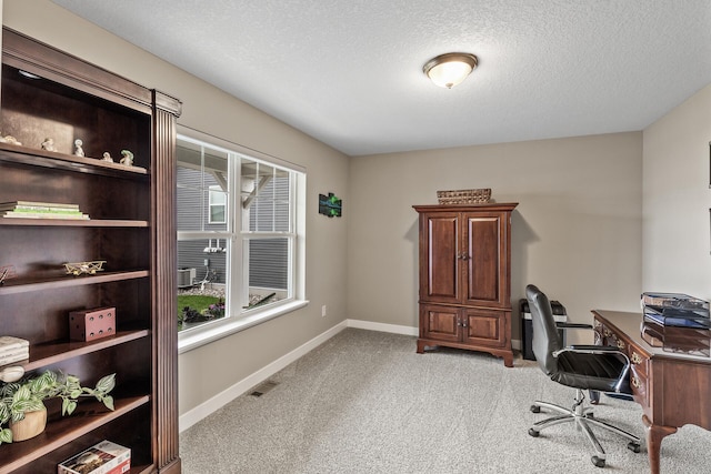 home office featuring a textured ceiling, visible vents, light carpet, and baseboards