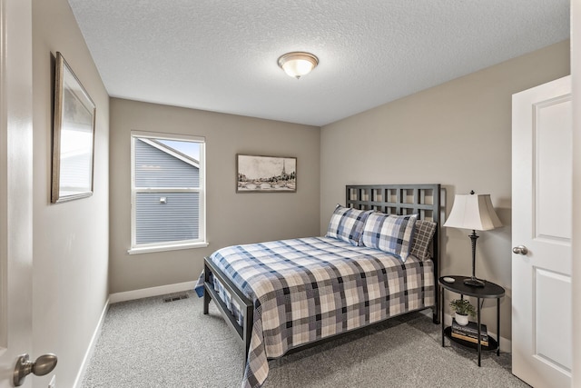 bedroom with baseboards, carpet, a textured ceiling, and visible vents
