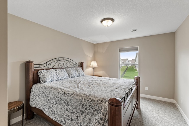 bedroom with baseboards, carpet flooring, and a textured ceiling