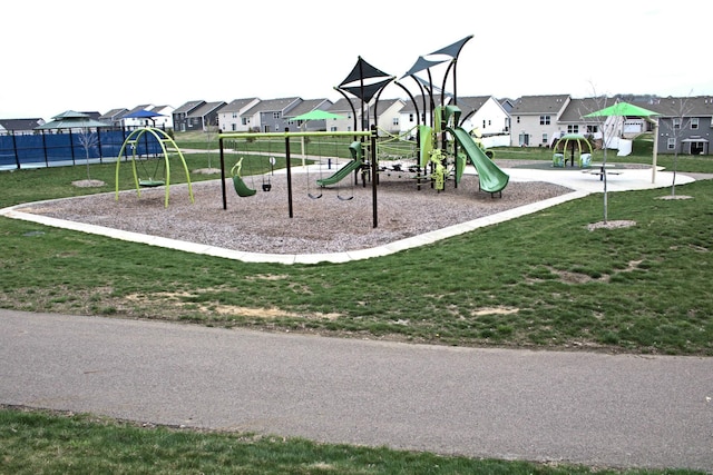 community playground with a yard, fence, and a residential view