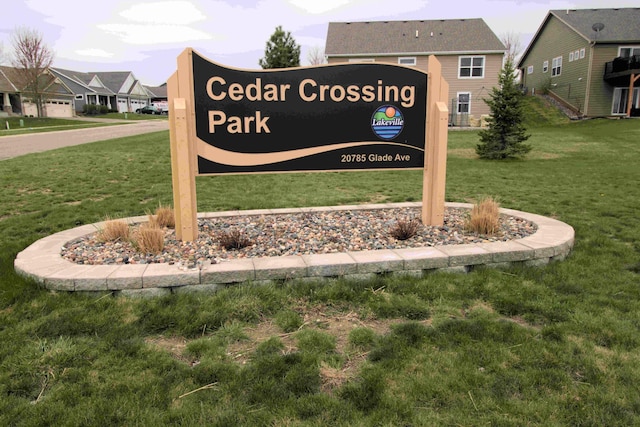 community / neighborhood sign with a residential view and a lawn
