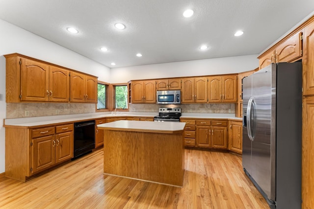 7884 341st St, Lent Twp, MN 55079 - kitchen with appliances with stainless steel finishes, light countertops, decorative backsplash, light wood-style floors, and brown cabinetry