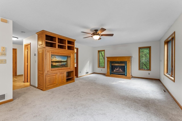 7884 341st St, Lent Twp, MN 55079 - unfurnished living room featuring a ceiling fan, light carpet, and a high end fireplace