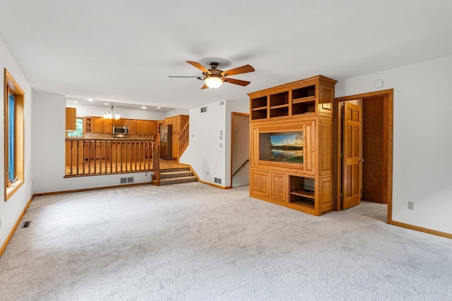 7884 341st St, Lent Twp, MN 55079 - unfurnished living room with ceiling fan, light carpet, stairs, and a chandelier