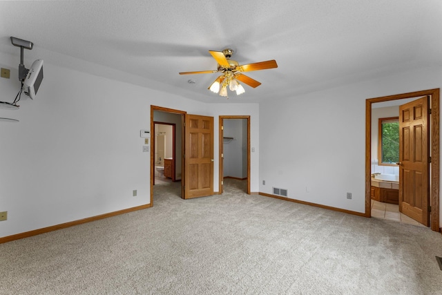 7884 341st St, Lent Twp, MN 55079 - unfurnished bedroom with light carpet, a walk in closet, ensuite bath, and ceiling fan