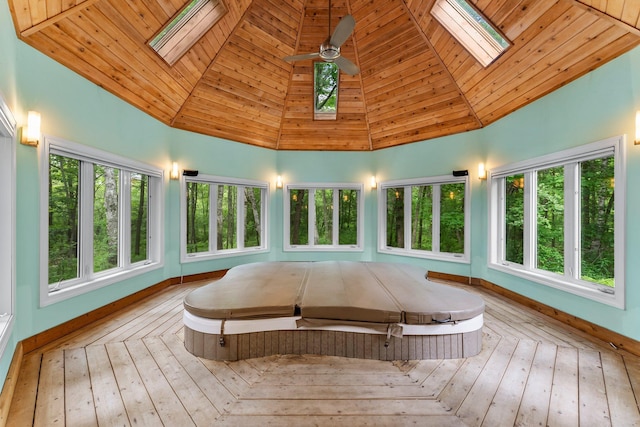 7884 341st St, Lent Twp, MN 55079 - sunroom featuring a skylight, a jacuzzi, a deck, high vaulted ceiling, and wooden ceiling